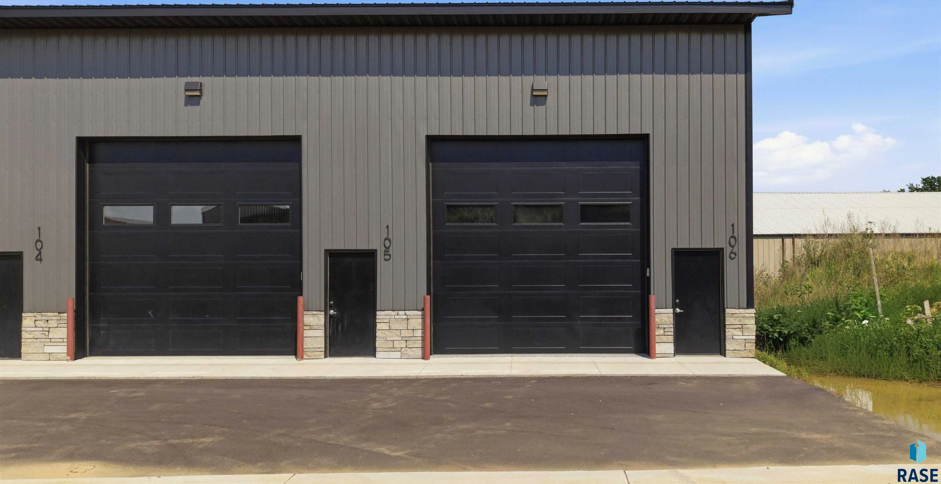 Front elevation of Arrowhead Storage Condos on Arrowhead Parkway in Sioux Falls, black garage doors with stone accents